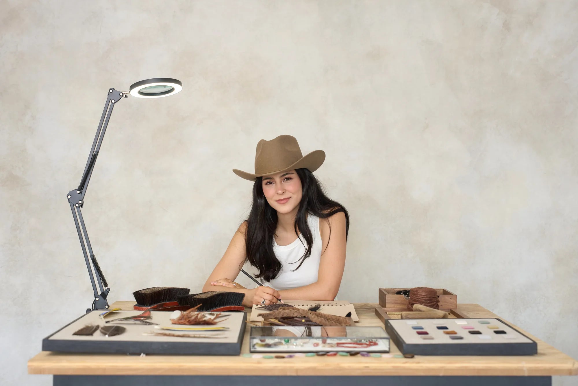 Luisa Fernē in her workshop, crafting a hat by hand